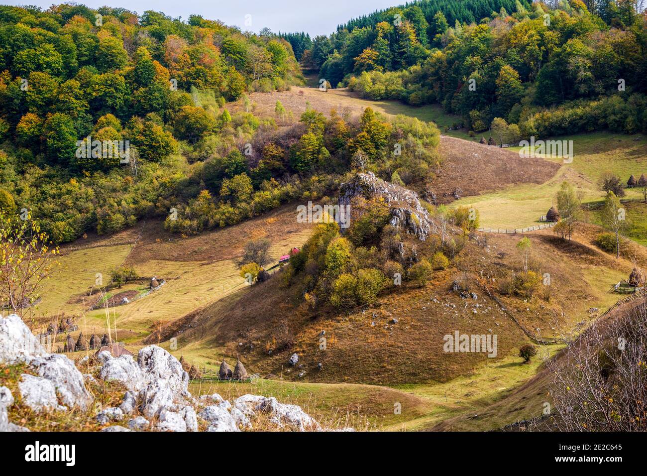 Autumn view of the wolf rock looking down on a small remote mountain village on Fundatura Ponorului. Photo taken on 5th of October 2019 in Fundatura P Stock Photo