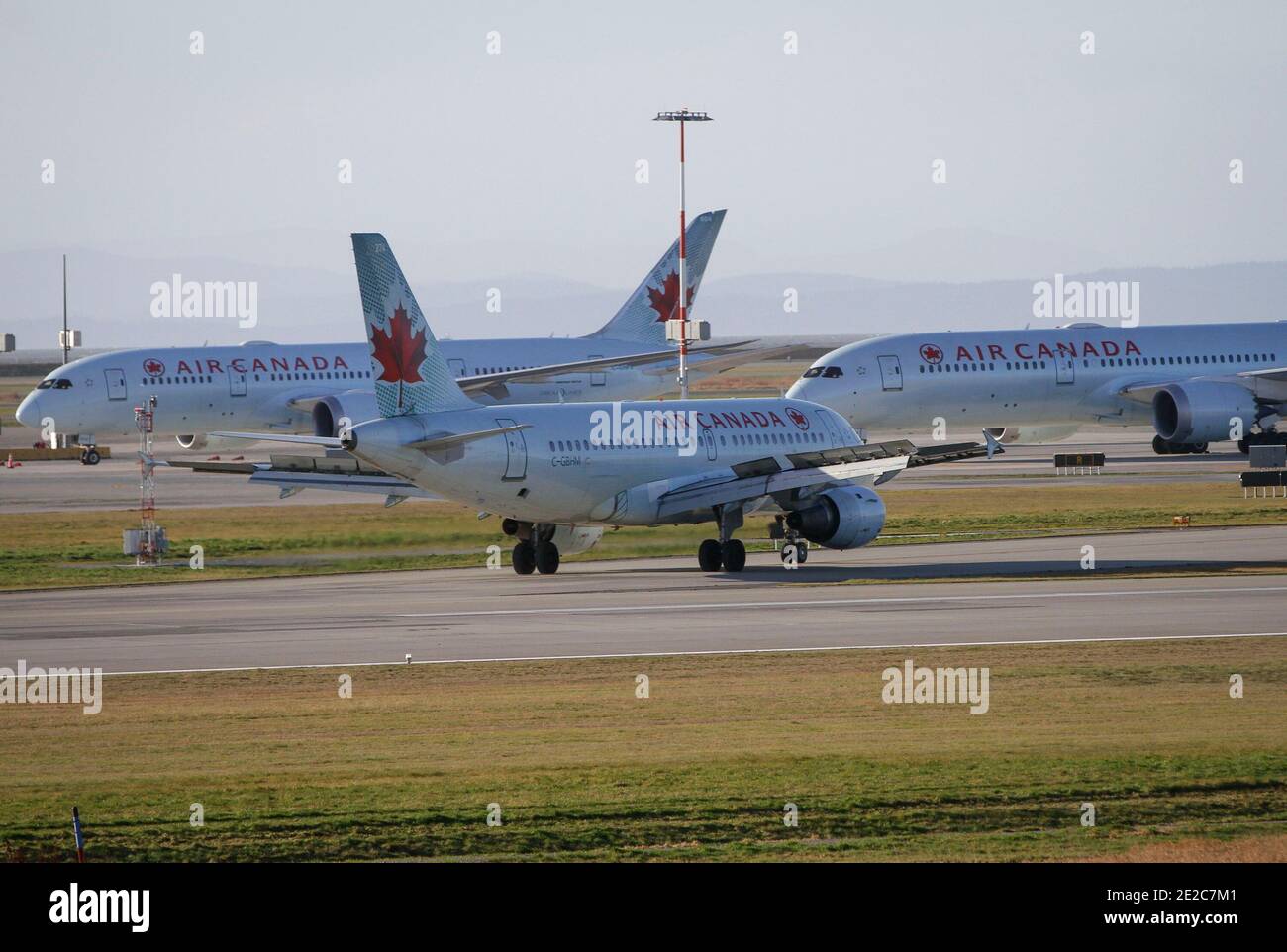 Richmond, Canada. 13th Jan, 2021. Air Canada aircrafts are seen on the runway of Vancouver International Airport in Richmond, British Columbia, Canada, Jan. 13, 2021. Air Canada announced on Wednesday that it is laying off about 1,700 employees due to official travel restrictions against the rampaging COVID-19 pandemic. Credit: Liang Sen/Xinhua/Alamy Live News Stock Photo