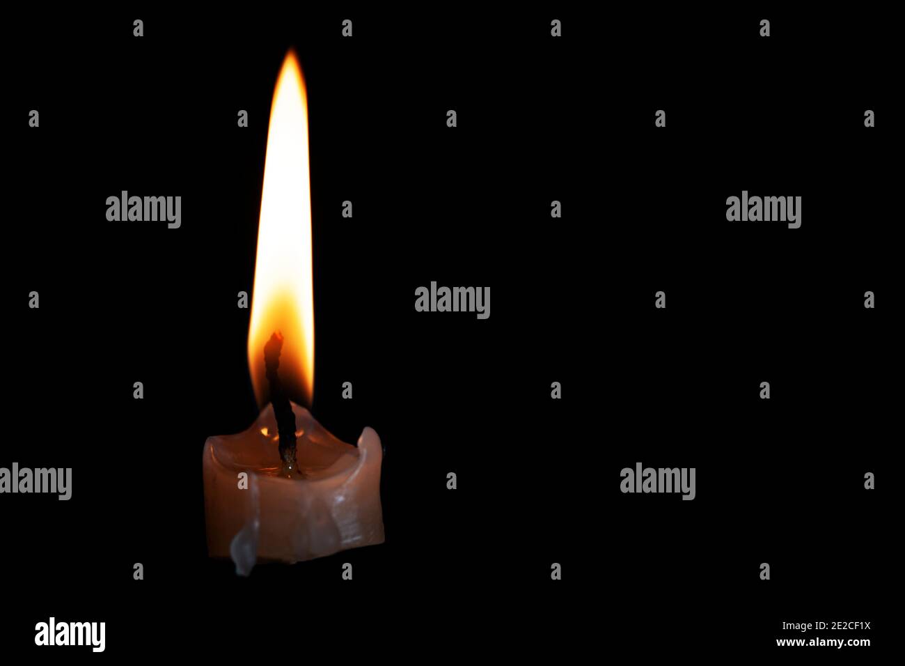 Light candle burning brightly in the black background Stock Photo
