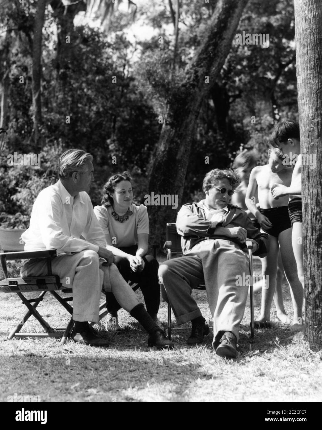 Director VICTOR FLEMING ANNE REVERE and SPENCER TRACY signing autographs for Children on set location candid near Juniper Springs in the Ocala National Forest of Florida during filming of the subsequently aborted film version of THE YEARLING ( from the novel Marjorie Kinnan Rawlings ) in May 1941 publicity for Metro Goldwyn Mayer Stock Photo