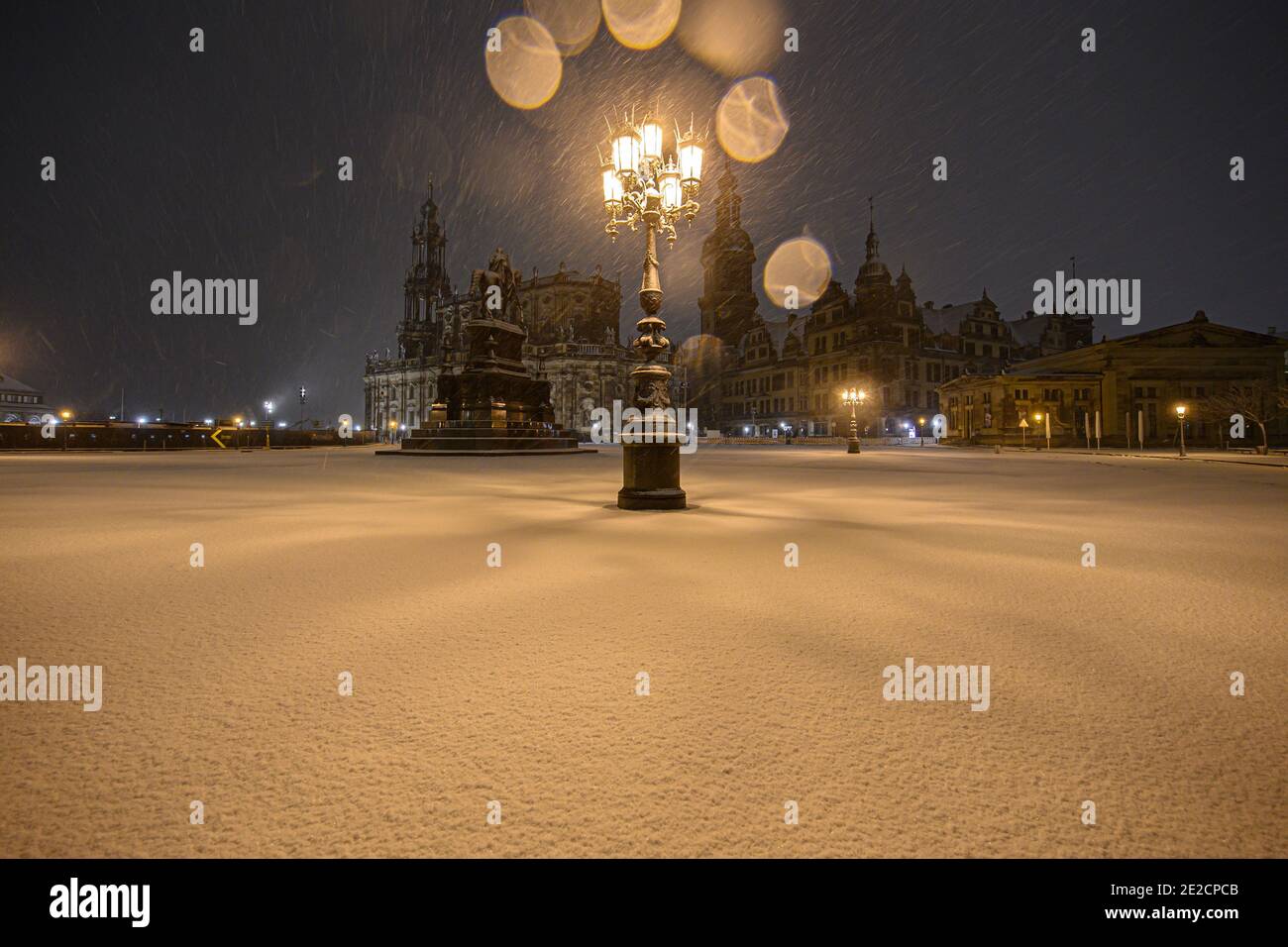 Dresden, Germany. 13th Jan, 2021. It snows in the evening on the Theaterplatz in front of the Hofkirche (l-r), the equestrian statue of King Johann, the Hausmannsturm, the Residenzschloss and the Schinkelwache. Credit: Robert Michael/dpa-Zentralbild/dpa/Alamy Live News Stock Photo