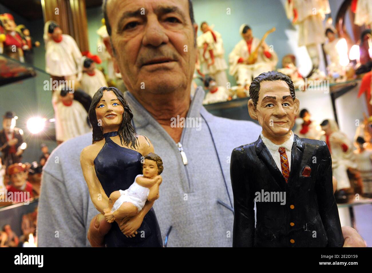 Artist Antonio Ferrigno shows statues of the french president Nicolas Sarkozy , his wife Carla Bruni and their new born baby in Via San Gregorio Armeno, in central Naples , Italy on october 19, 2011. The price is 300 Euros. Representations of topical characters ,celebrities, politicians...often show up in the crib, adding a humorous touch.In recent decades, artists and craftsmen of these shops have been making Neapolitan creches, pertaining to the southern Italian city of Naples, with statues of prominent figures placed near the nativity scenes.These statues portray the signs of the times, acc Stock Photo