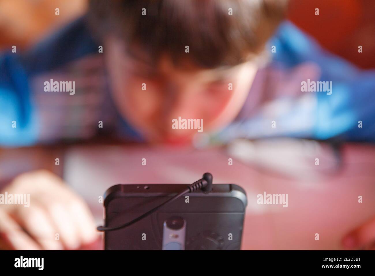 home online training, a boy using a mobile phone and headphones is