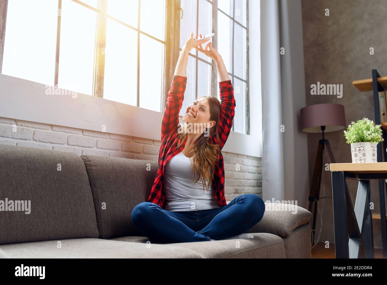 Happy woman relaxing on a sofa at home Stock Photo