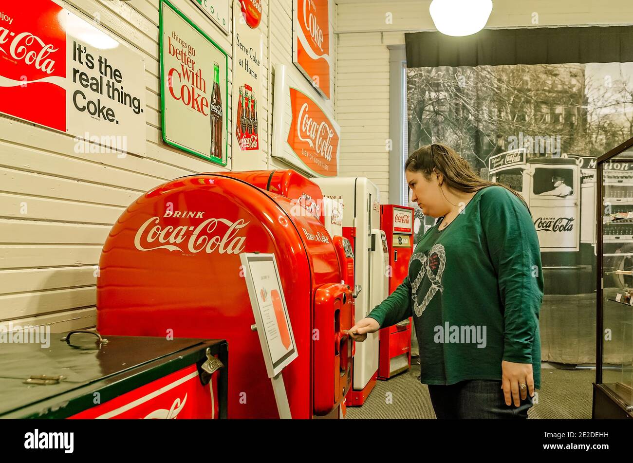 A woman inspects an antique Coke machine as she walks through the Coca-Cola Museum in Corinth, Mississippi, March 5, 2012. Stock Photo