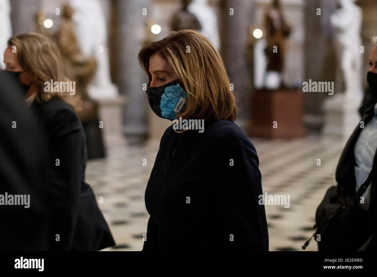 Washington, USA. 13th Jan, 2021. U.S. House Speaker Nancy Pelosi wearing a protective mask walks through the hallways in Capitol Building in Washington, DC, the United States, Jan. 13, 2021. A majority of lawmakers in the U.S. House on Wednesday voted for impeaching President Donald Trump over 'incitement of insurrection,' making him the first president to be impeached twice. Credit: Ting Shen/Xinhua/Alamy Live News Stock Photo