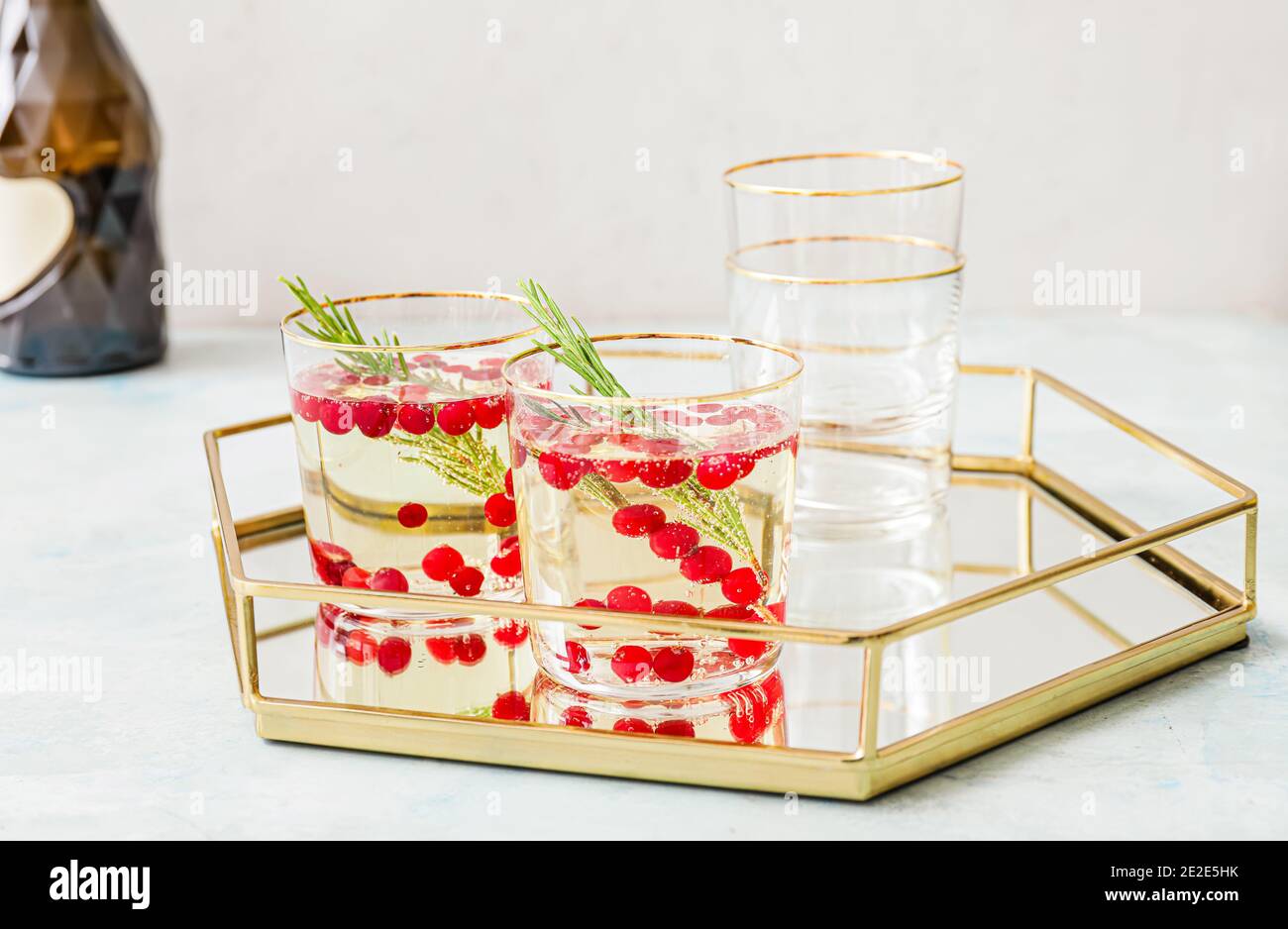 Glasses of champagne cocktail with cranberry and rosemary on tray Stock Photo