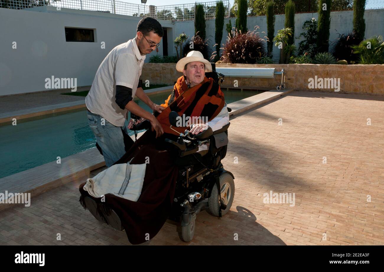 EXCLUSIVE - Philippe Pozzo di Borgo, who became quadriplegic after a paragliding accident in 1993, poses with new auxiliary Hakim at his home in Essaouira, Morocco, November 15, 2011. His story inspired the movie 'Intouchables' directed by Olivier Nakache and Eric Toledano, released in France on November 2011, in which the actor Francois Cluzet plays his role and actor Omar Sy plays Abdel Seliou's role. In France, the movie reached 10 million of filmgoers. Photo by William Stevens/ABACAPRESS.COM Stock Photo