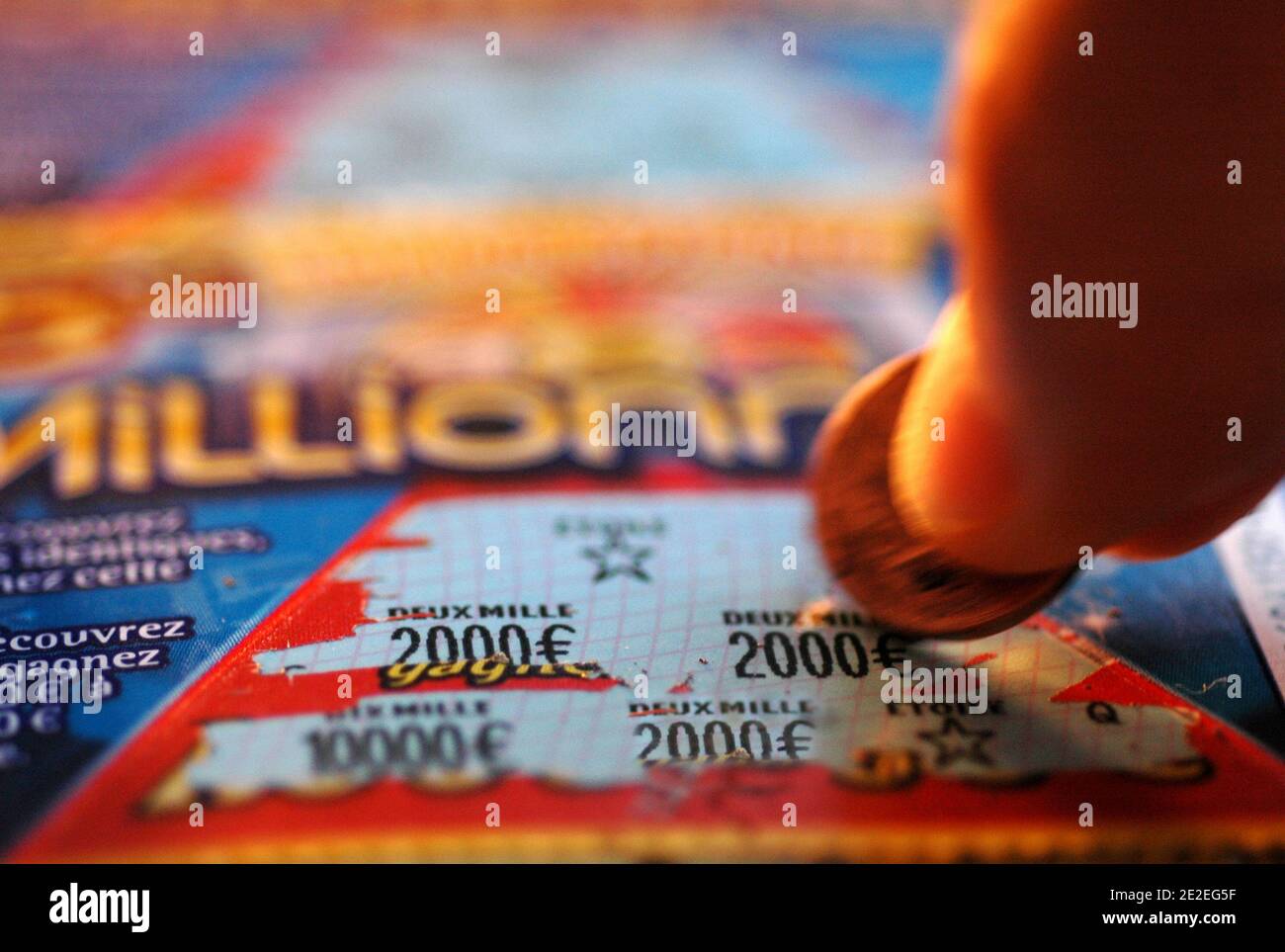 The  Millionnaire , scratch game, gambling in the FDJ (Française des Jeux  ).Scratch, coin, hands, fingers, close-up, 2011. Le millionnaire, jeu de  grattage, jeu d'argent de la FDJ( Française des Jeux ).
