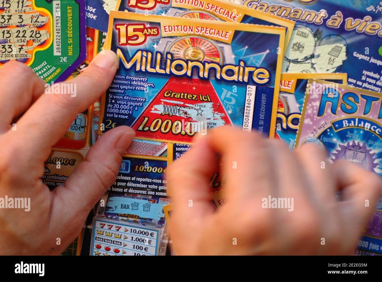 The  Millionnaire , scratch game, gambling in the FDJ (Française des Jeux  ).Scratch, coin, hands, fingers, close-up, 2011. Le millionnaire, jeu de  grattage, jeu d'argent de la FDJ( Française des Jeux ).