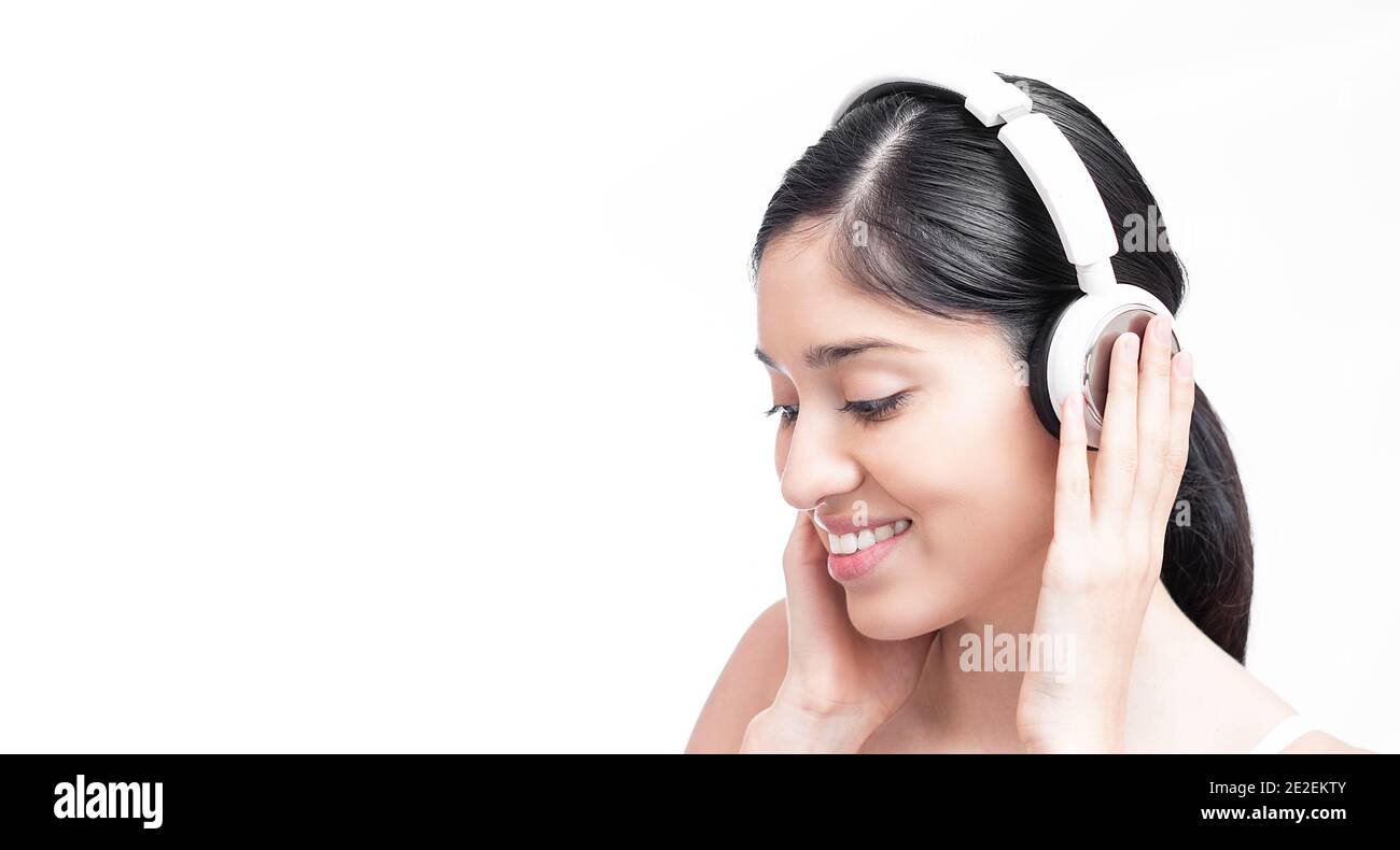 Closeup of a Hispanic female listening to music with her headphones ...
