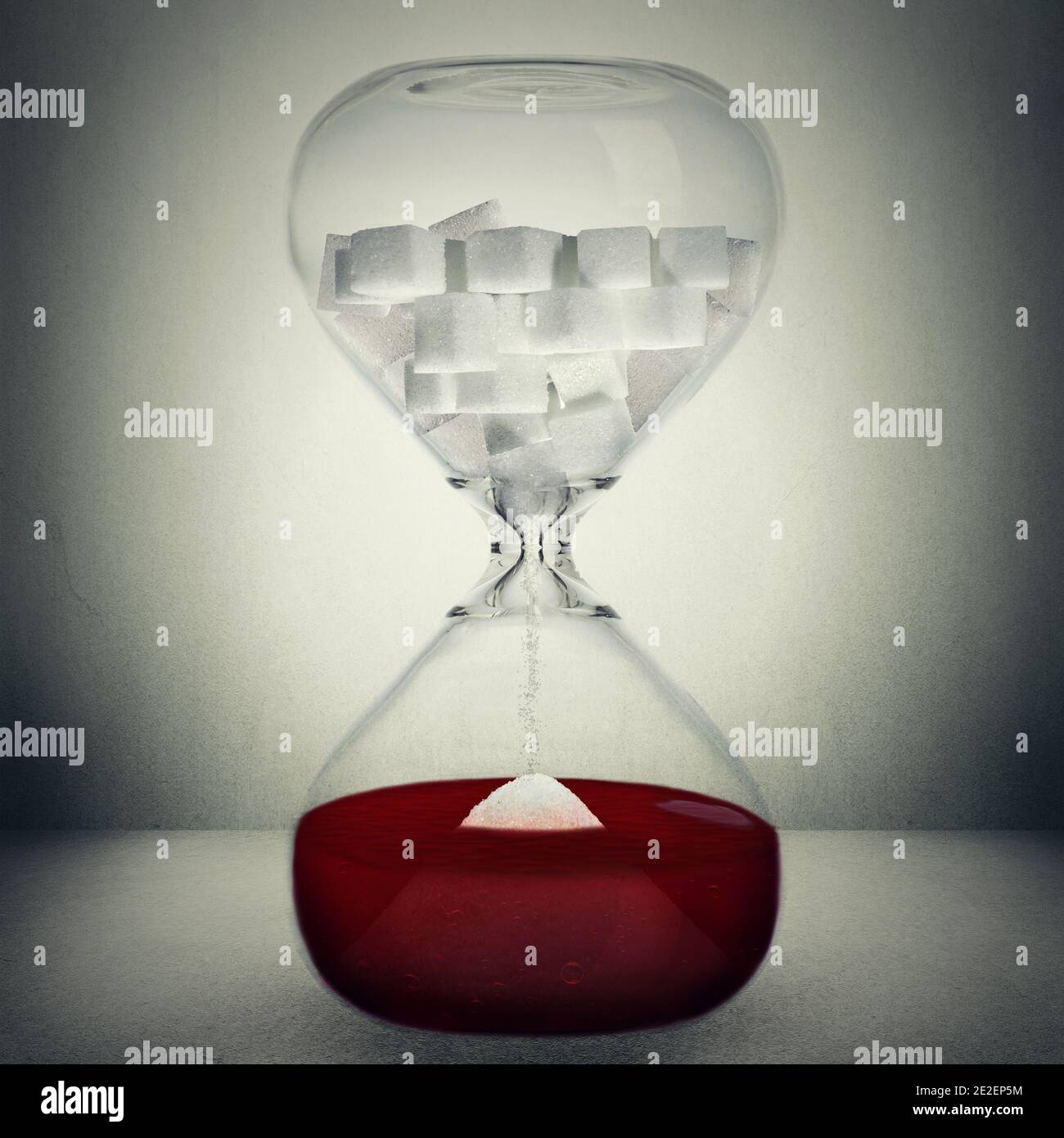 Sugar kills your blood and body in time concept isolated on grey background. Closeup of a Hourglass with sugar in cubes that are pouring down into sug Stock Photo