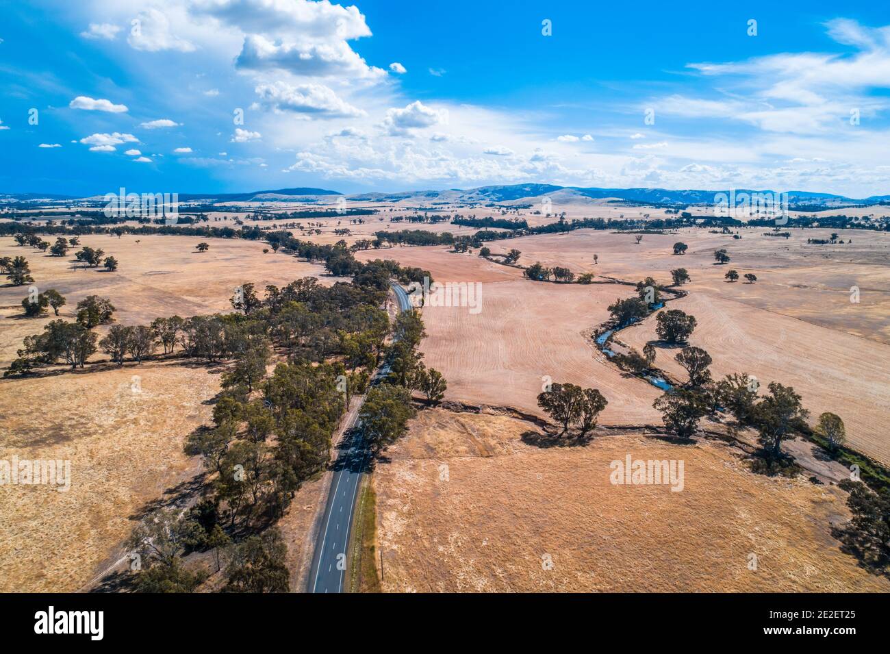 Rural highway winding through Australian outback on hot summer day ...