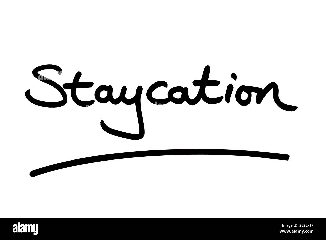 The word Staycation handwritten on a white background. Stock Photo