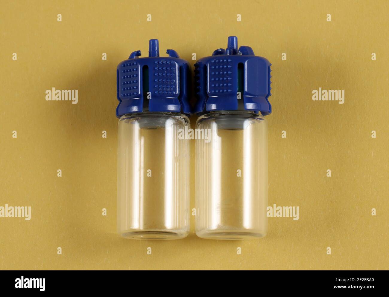 Empty glass vials for medical equipment like vaccine on yellow background Stock Photo