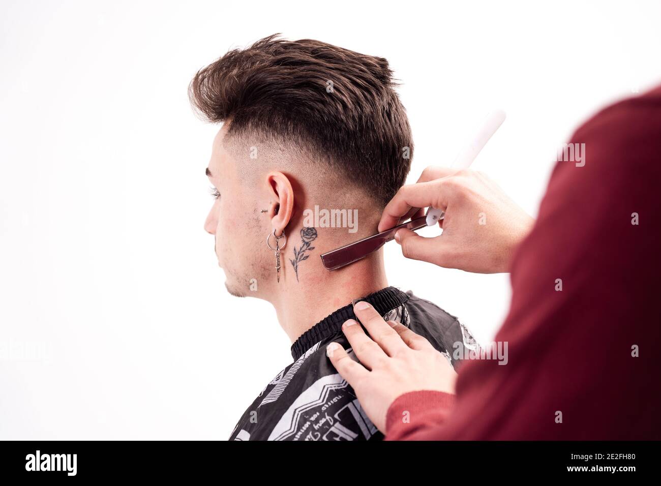 Barber cutting client's hair with razor Stock Photo - Alamy