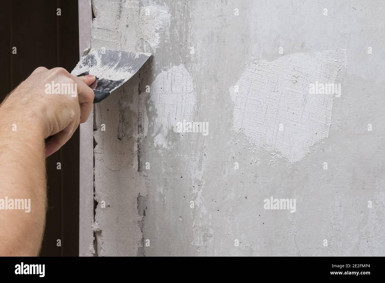 The man is plastering the walls in the room. Close-up. Stock Photo