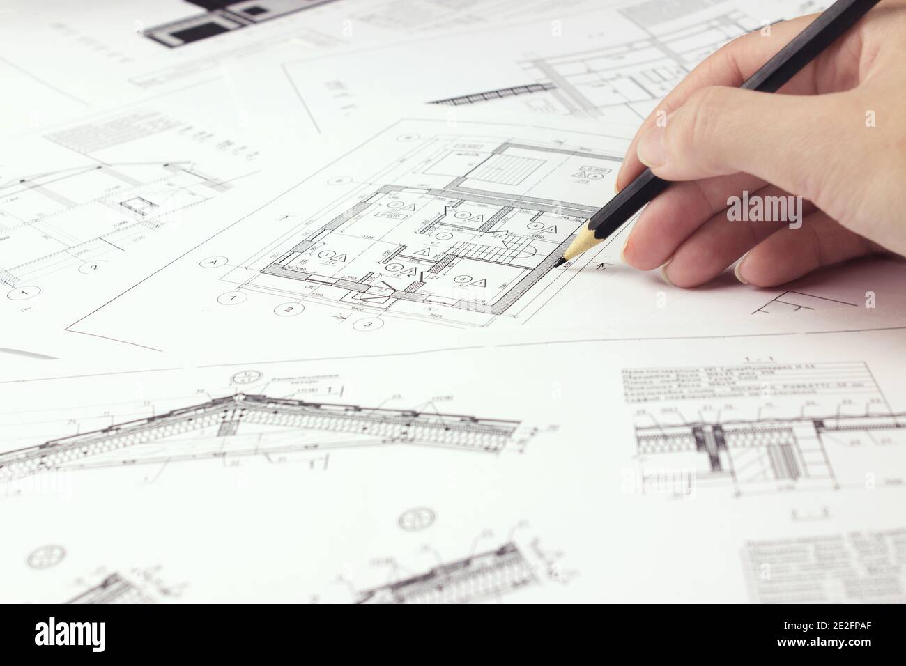 Designer are working on a new project blueprint Design at desk in office. Architects workplace - architectural project and hand with pencil. Architect Stock Photo