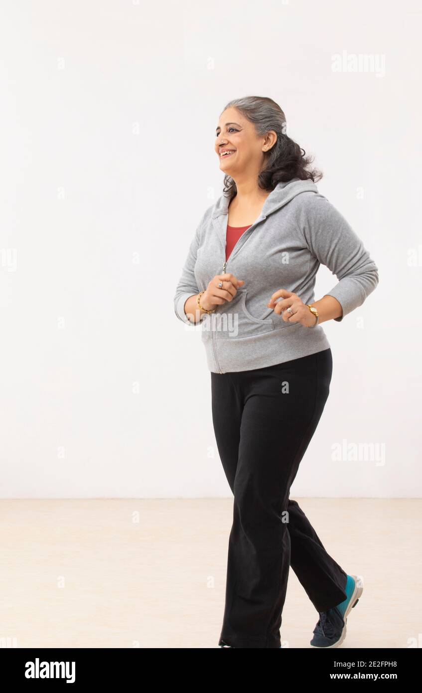 A SENIOR ADULT WOMAN HAPPILY JOGGING Stock Photo