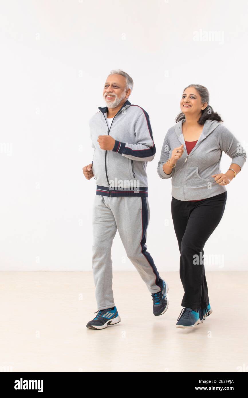 A SENIOR COUPLE JOGGING TOGETHER HAPPILY Stock Photo