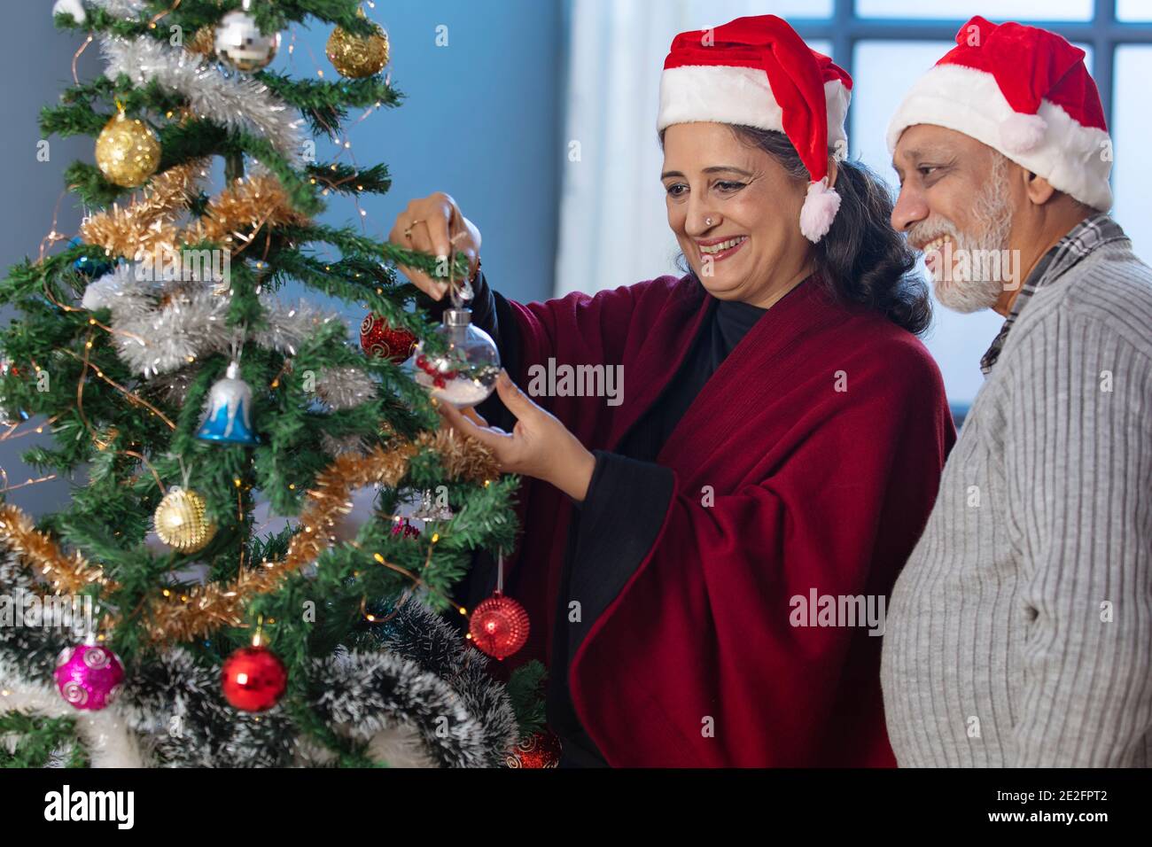 94 9 Christmas 2022 A Happy Old Couple Decorating Christmas Tree Together Stock Photo - Alamy
