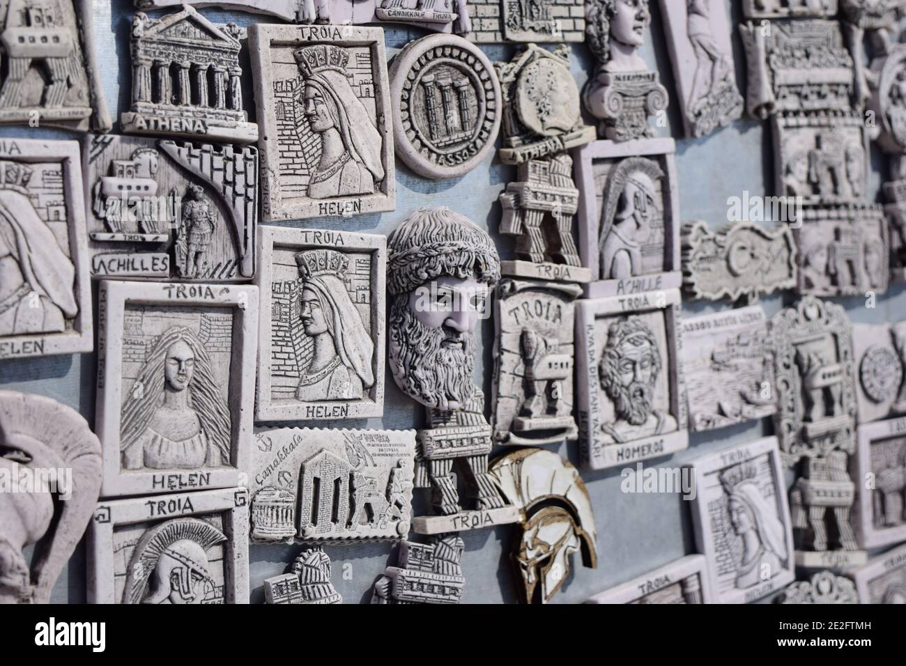 Selective shot of small sculpted images about Greece and Greek gods mounted on the wall Stock Photo