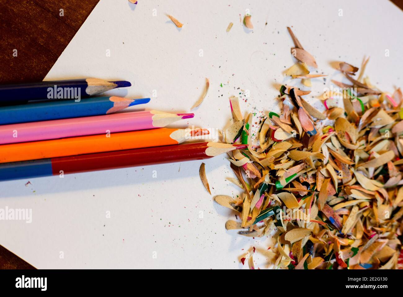 Top view of colored pencils with shavings and pencil sharpener over white  background. top view Stock Photo - Alamy