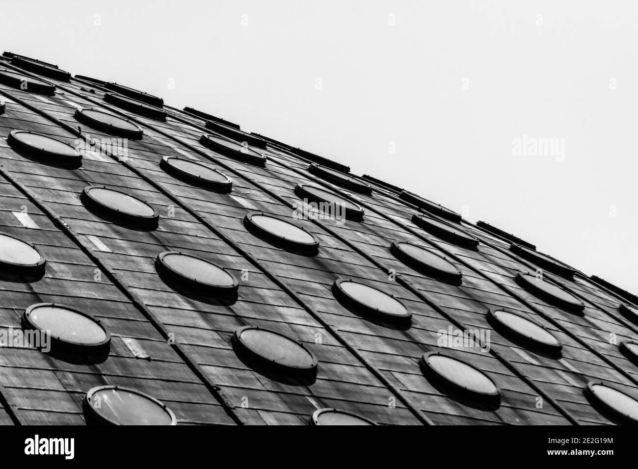 Closeup grayscale of a roof of a house with many round windows Stock Photo