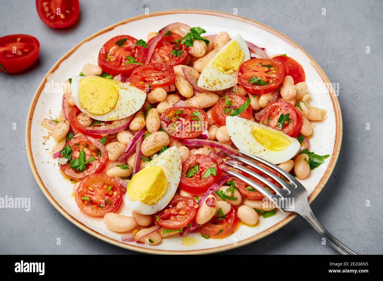 A Piyaz salad on white plate on gray concrete table top. Turkish cuisine vegetarian dish. Middle eastern cuisine food. Close up Stock Photo