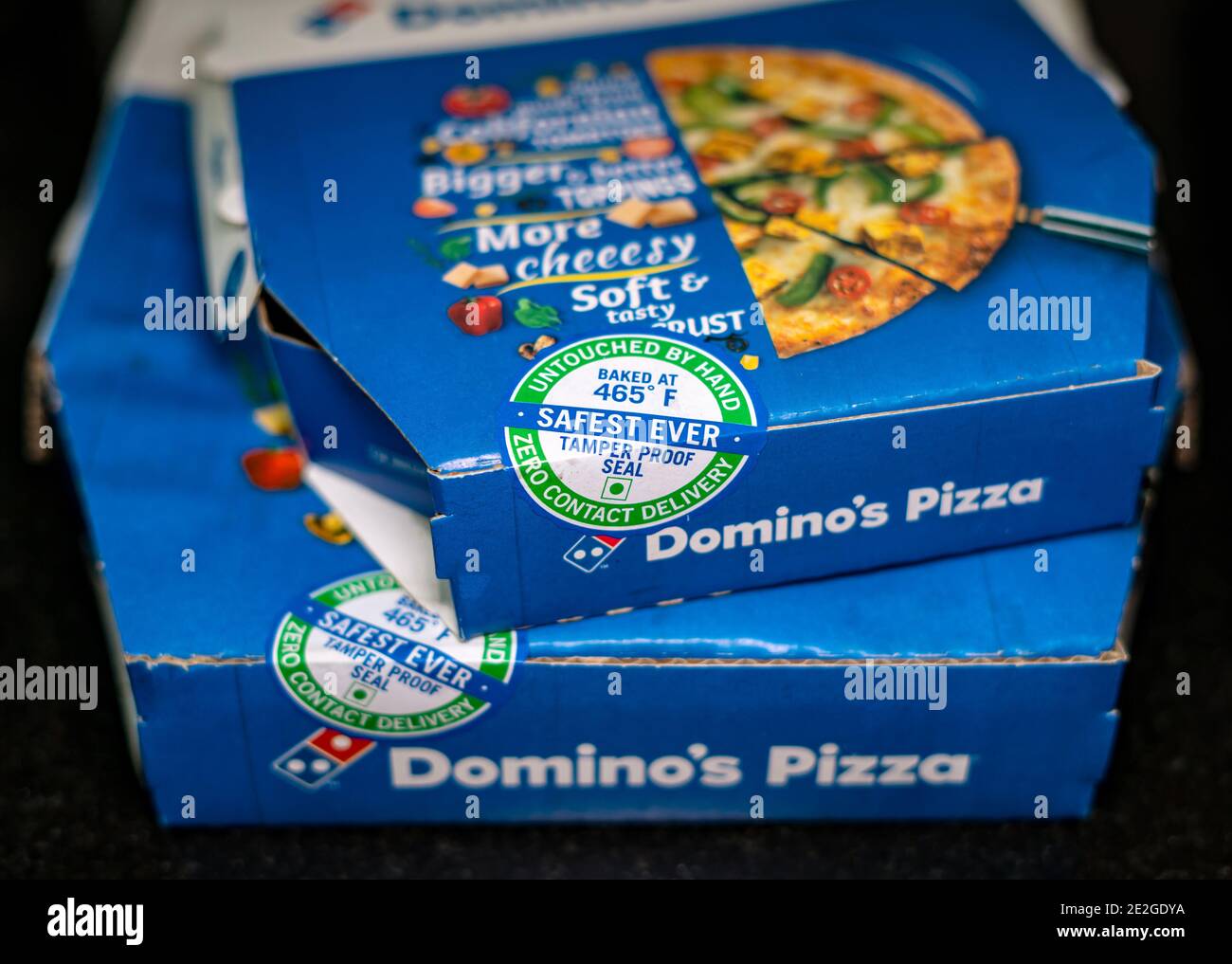 Stacked Domino's pizza boxes sealed with tamper proof seal for zero contact delivery. Stock Photo