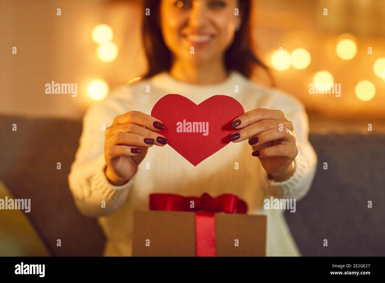 Smiling woman girlfriend showing red heart to her boyfriend during online dating Stock Photo
