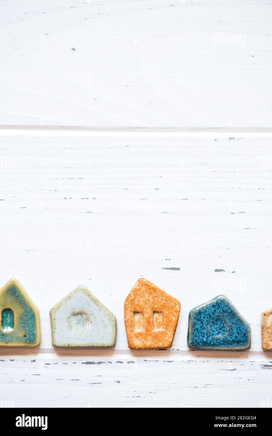 Colorful ceramic houses on a white wooden background. Stock Photo