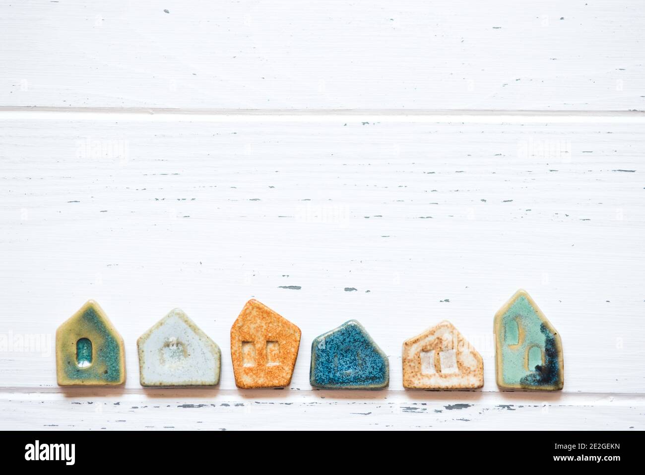 Colorful ceramic houses on a white wooden background. Stock Photo