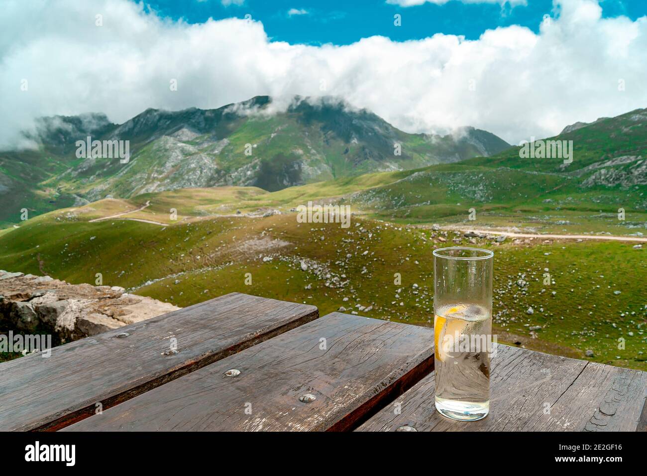 Crystal glass on table in the mountains.The photography aims to show the relaxation and disconnection that nature offers us. Stock Photo