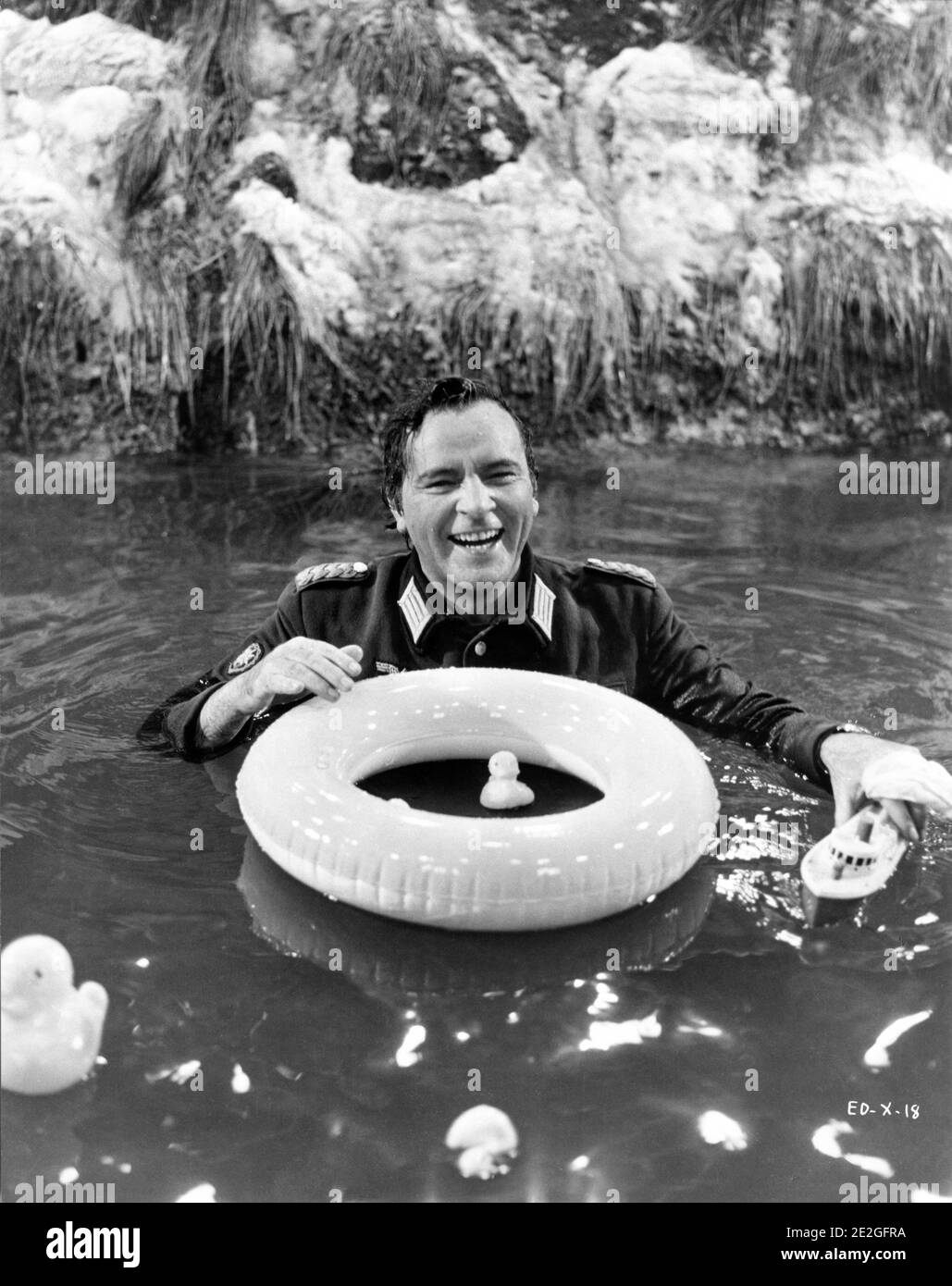 RICHARD BURTON on set gag publicity shot with rubber ducks and swimming ring in studio set of river in Nazi Uniform during filming of WHERE EAGLES DARE 1968 director BRIAN G. HUTTON story / screenplay Alistair MacLean music Ron Goodwin producers Elliot Kastner and Jerry Gershwin  Gershwin-Kastner Productions / Winkast Film Productions / Metro Goldwyn Mayer Stock Photo