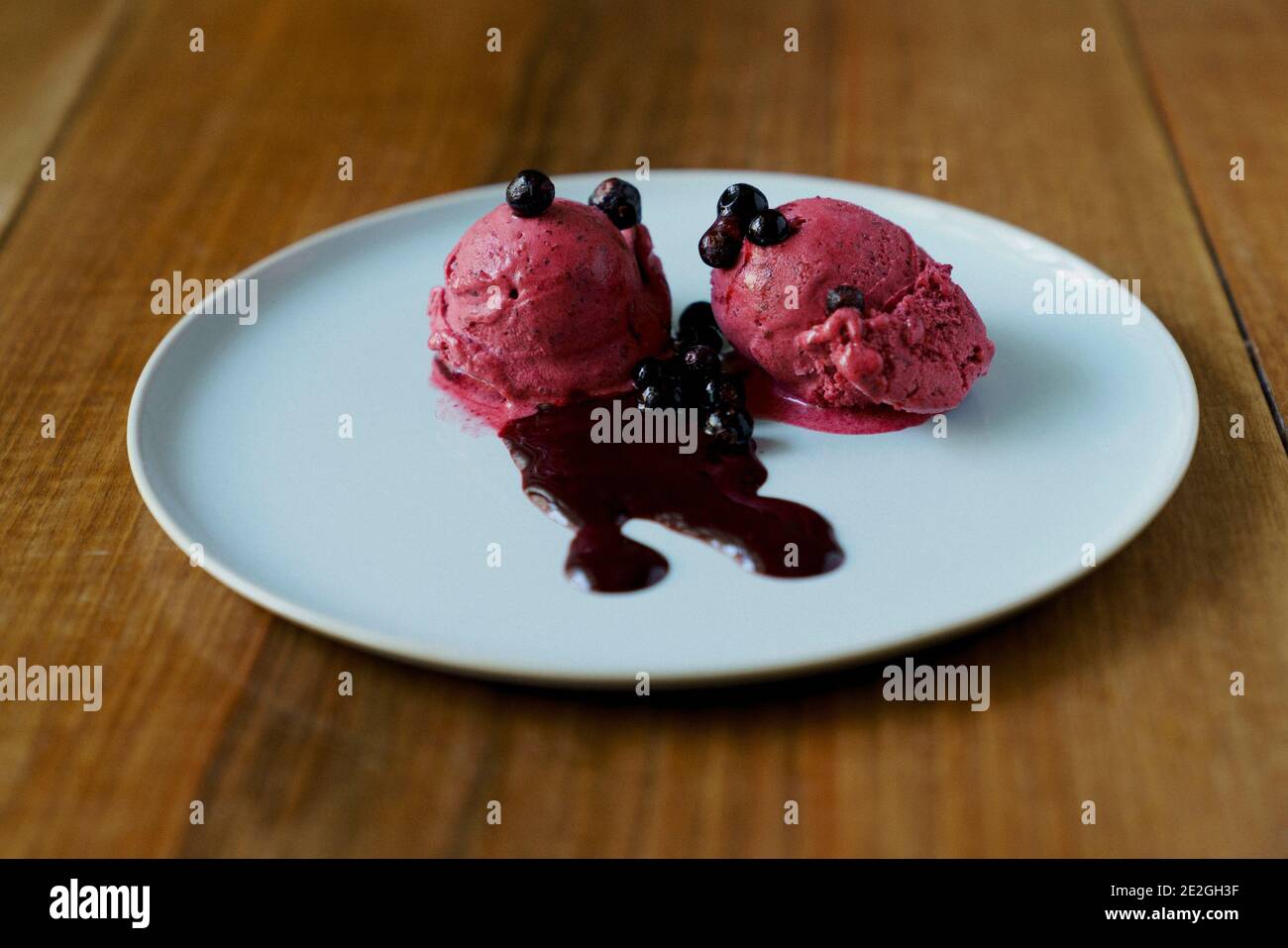 Raspberry sorbet with blueberry sauce on plate Stock Photo Alamy