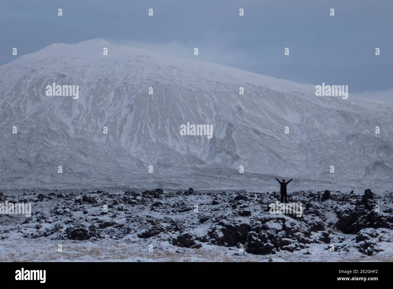 Exuberant woman in remote snowy mountain landscape, Sn fellsj kull, Iceland Stock Photo