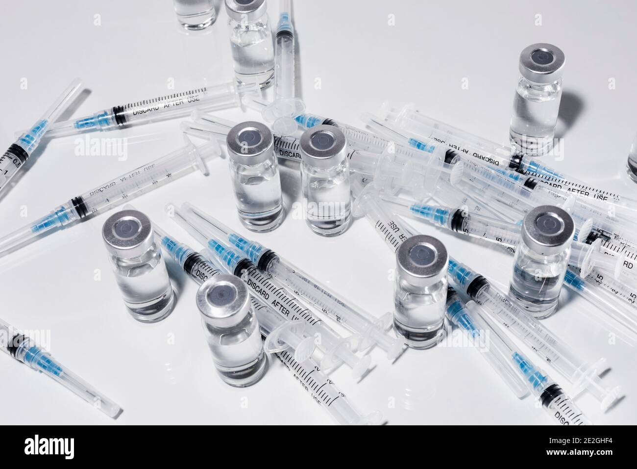 Syringes and COVID-19 vaccine vials on white background Stock Photo - Alamy