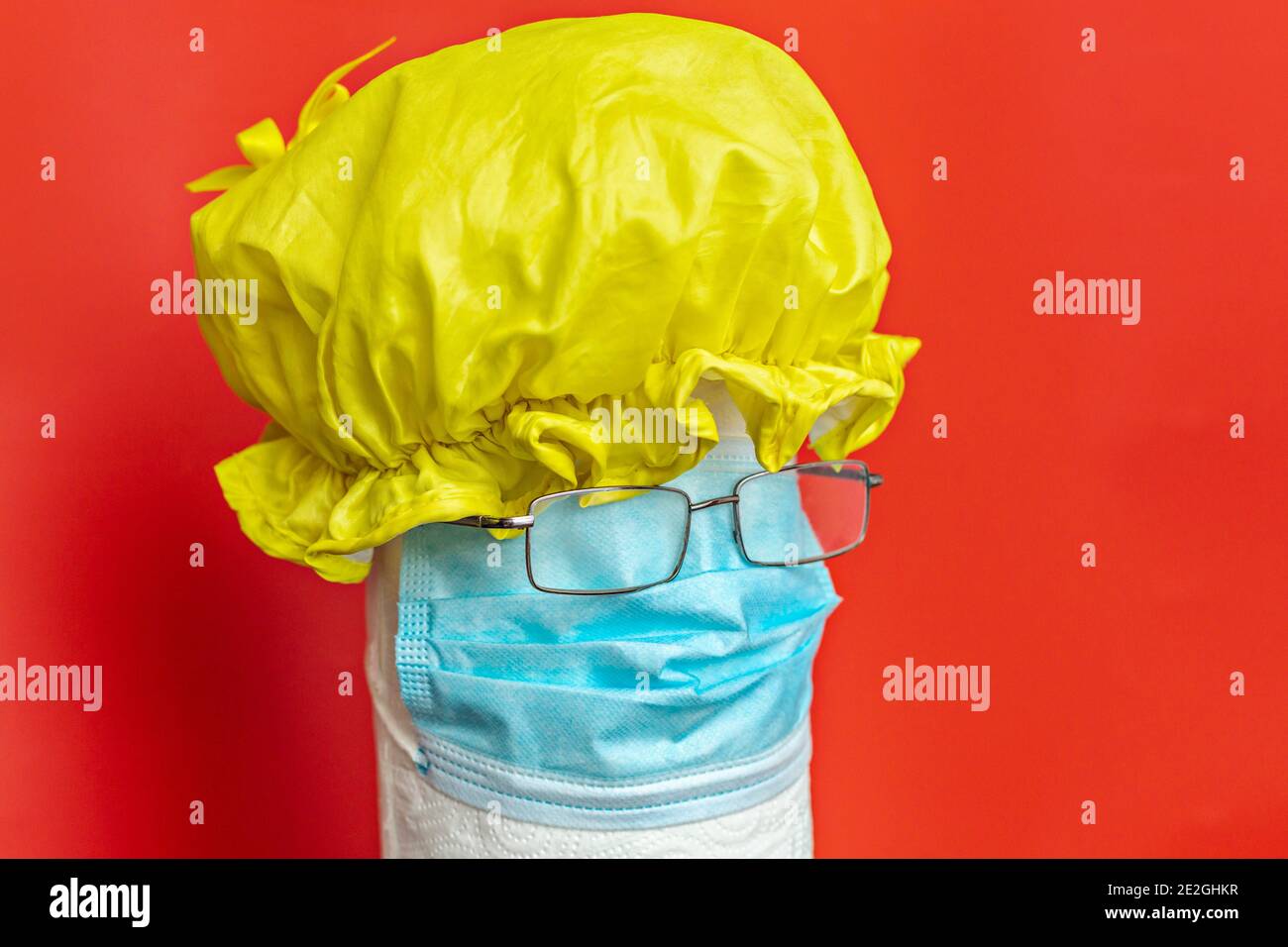 Shower cap, protective face mask and eyeglasses forming anthropomorphic face Stock Photo