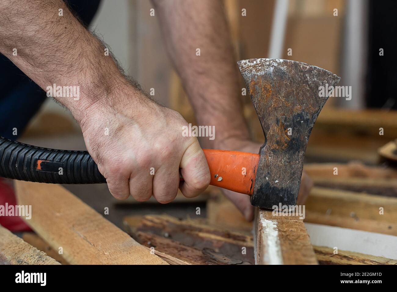 Male hands hammer nail with old ax. Multifunctionality of building elements during construction work. Life style photo Stock Photo