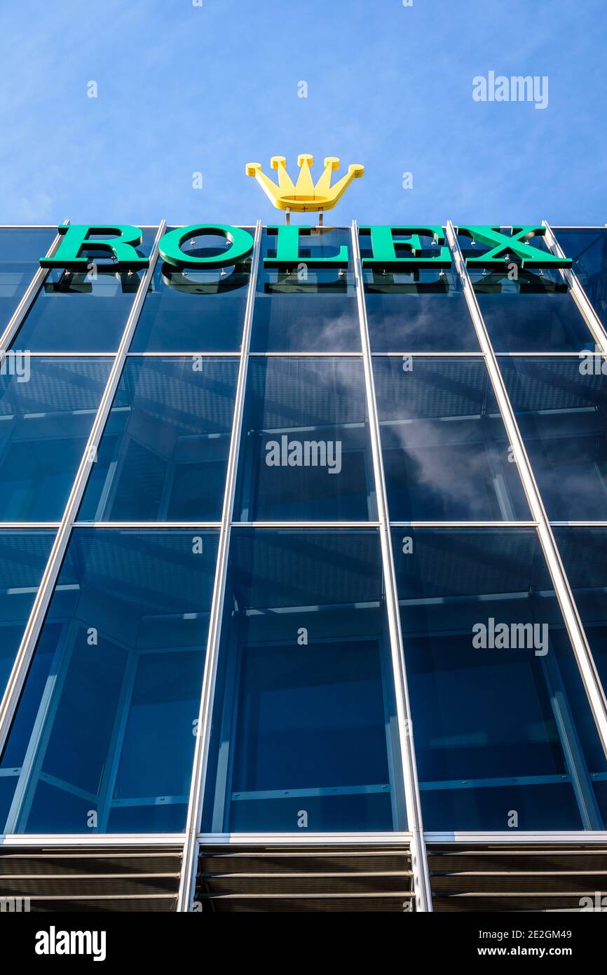 Low angle view of the Rolex logo at the top of a building at the headquarters of the swiss brand of luxury watches in Geneva. Stock Photo