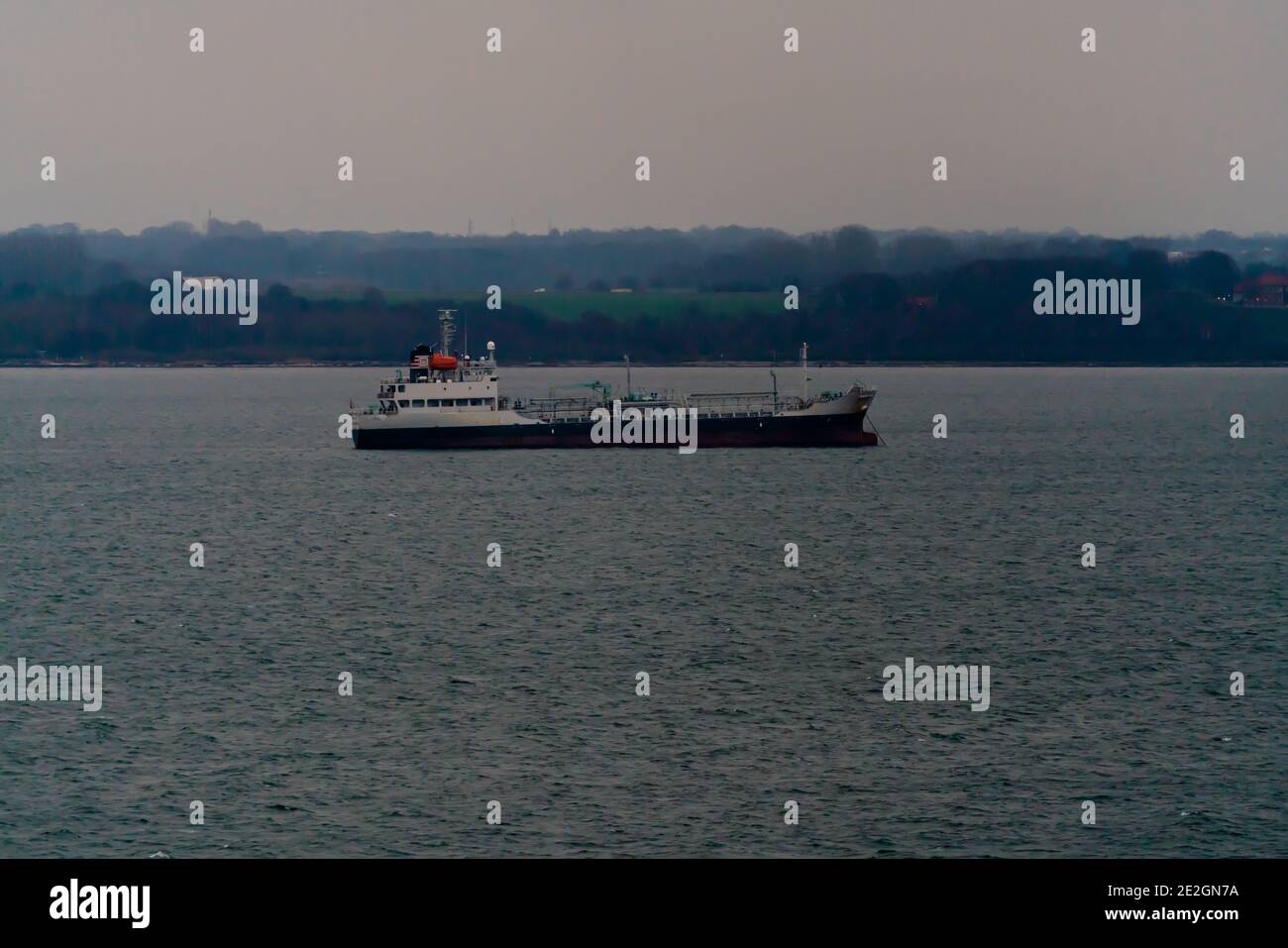 Old cargo ship at anchor off the coast waiting for charter. Stock Photo