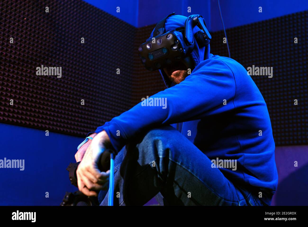 Man using virtual reality headset in dark room of vr gaming club ...