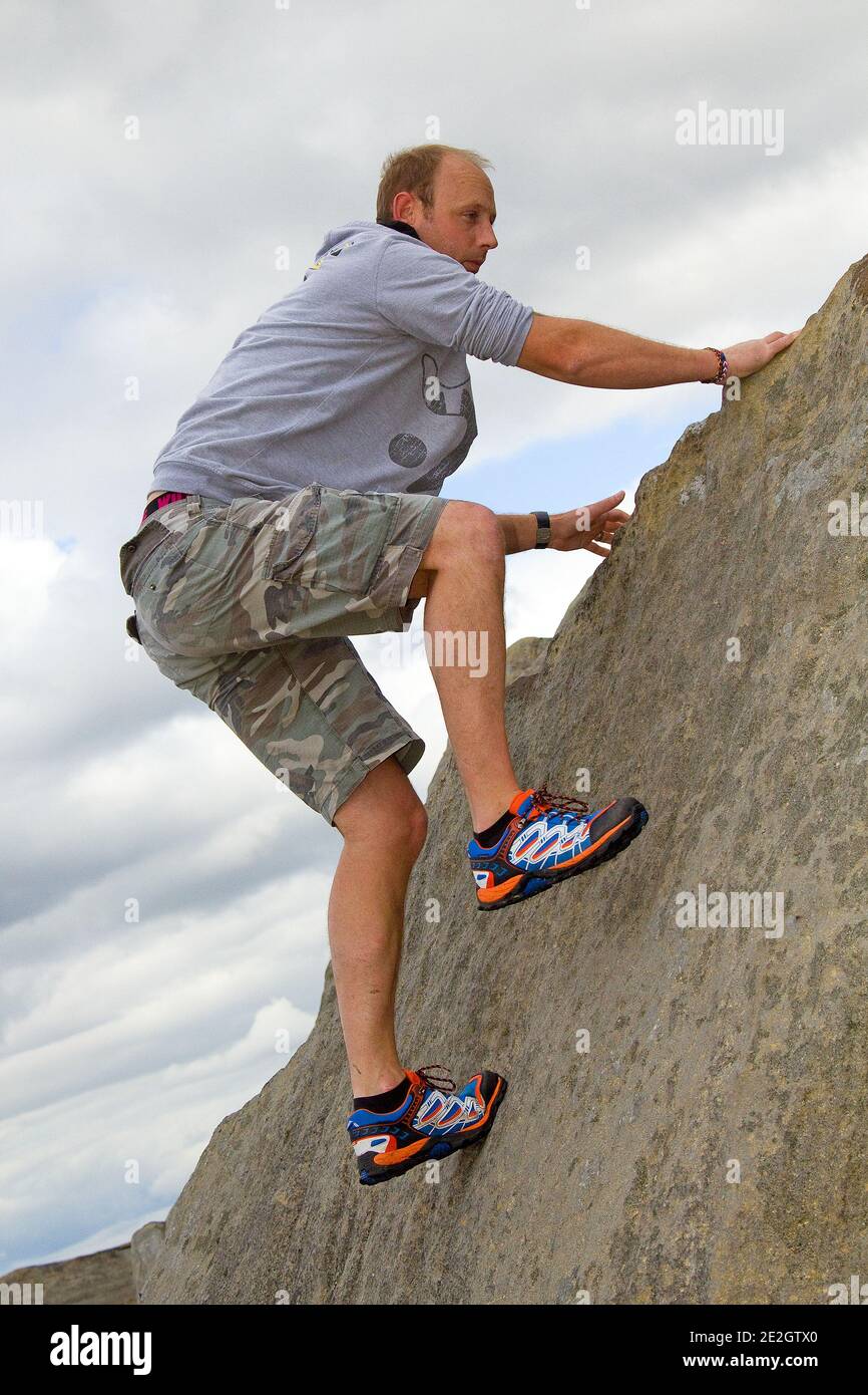 man jumping off rocks Stock Photo