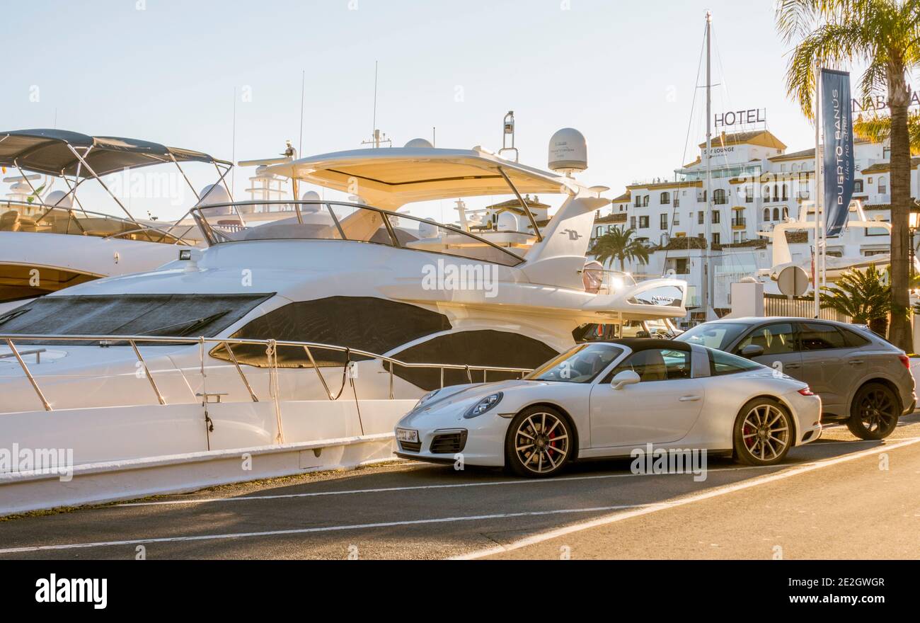 Puerto Banús, with luxury cars parked in port, Yachts behind, Marbella, Nueva Andalucia, Costa del sol, Andalucia, Spain. Stock Photo