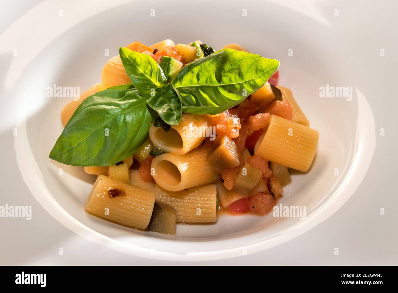 Italian pasta Mezzi Paccheri with tomato and eggplant sauce with basil leaves Stock Photo