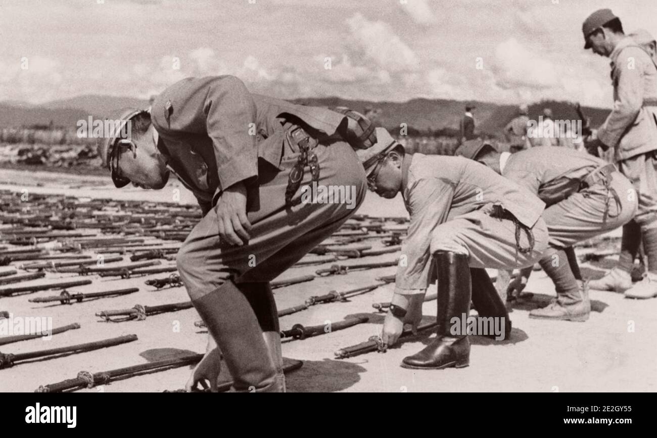 The surrender of Imperial Japan. Japanese soldiers lay down military officer's swords (shin gunto). 1945 Stock Photo