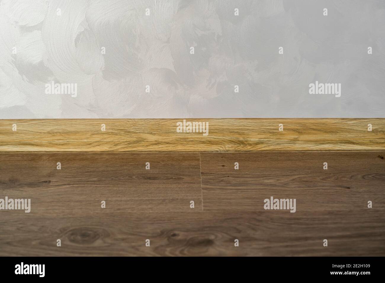 Laminate with plastic baseboard with a wooden texture. Newly installed