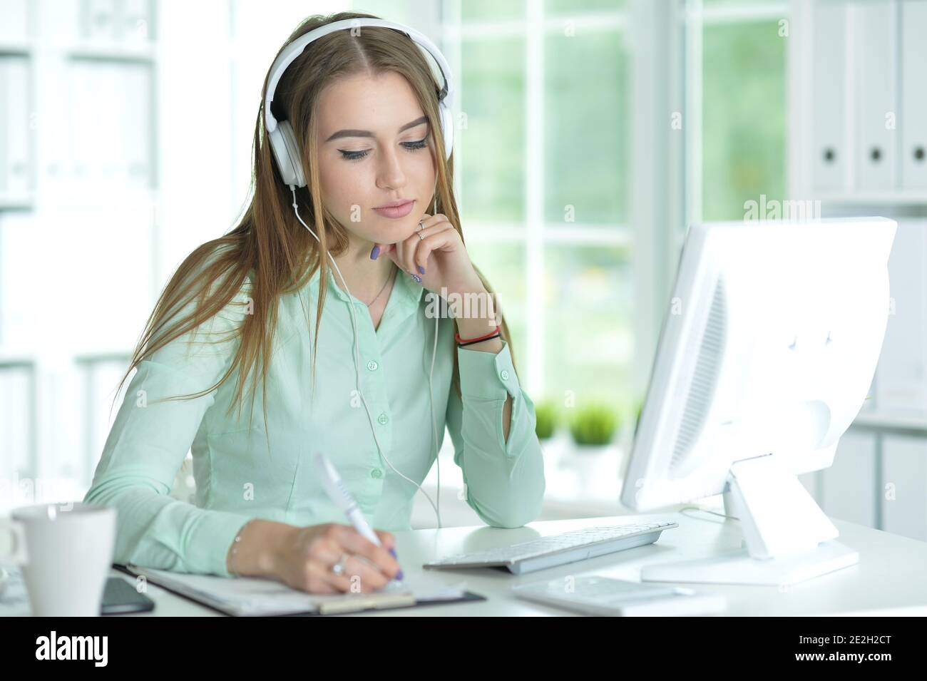 Portrait of businesswoman working in headphones in office Stock Photo ...