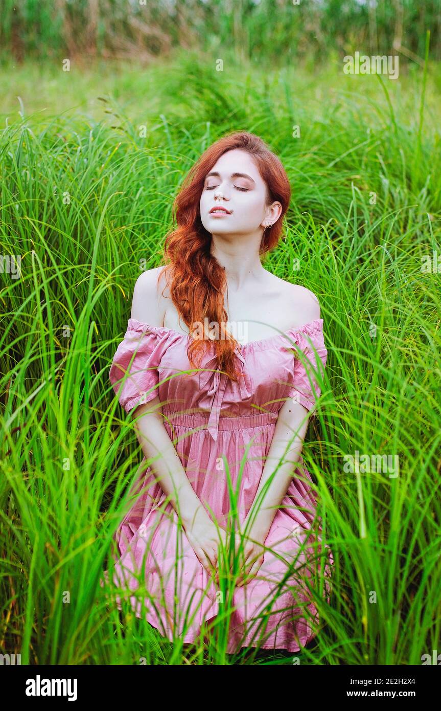Outdoor portrait of positive redhead woman in pink dress dancing in nature.  Woman's Day. Female spring, summer fashion concept. Happy lifestyle Stock  Photo - Alamy